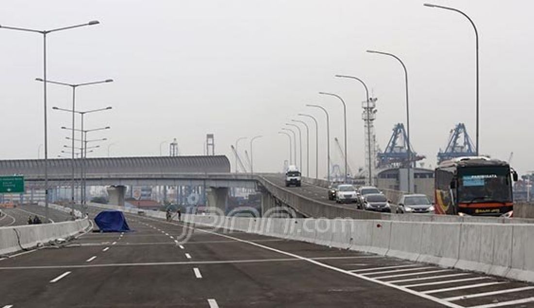 Suasana proyek pembangunan jalan tol akses pelabuhan Tanjung Priok, Jakarta, Senin (30/5). Pembangunan tol Tanjung Priok seksi E2 dengan rute Cilincing-Jampea sepanjang 2,74 km dan diperkirakan akan selesai pada triwulan I-2017. Foto: Ismail/Indopos/JPNN.com - JPNN.com