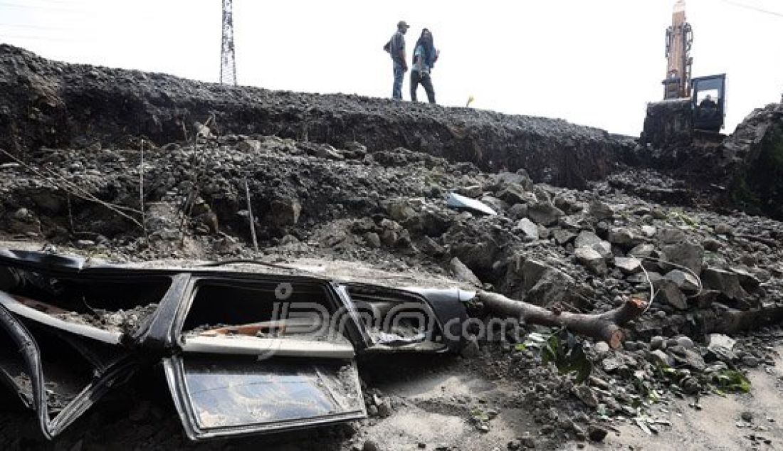 Sebuah mobil hancur tertimpa reruntuhan tembok pembatas jalan inspeksi Penghubung Kanal Banjir Barat, Duri Pulo, Gambir, Jakarta Pusat, Senin (13/6). Foto: Ricardo/JPNN.com - JPNN.com