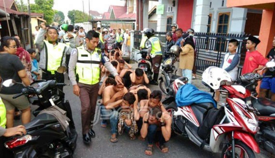 DIGELANDANG: Petugas kepolisian dari Polresta pekanbaru saat mengamankan ABG yang tawuran di jalan Ahmad Yani, Selasa (14/6). Foto: Sakiman/Riau Pos - JPNN.com