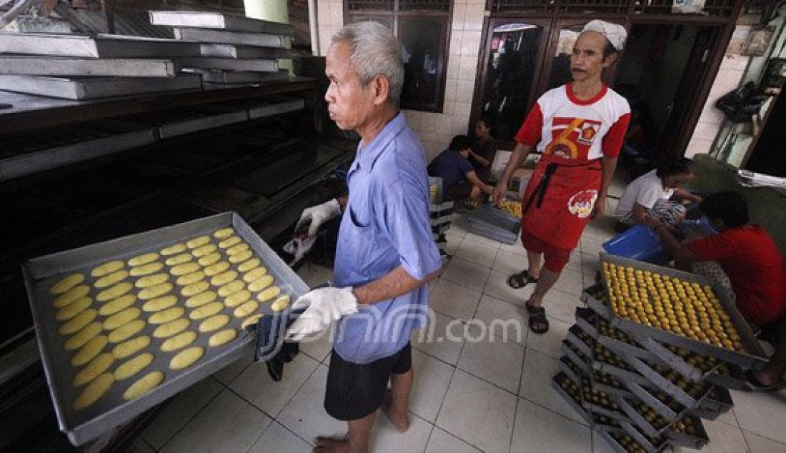 Pekerja menyelesaikan produksi kue kering industri kue rumahan di Kwitang, Jakarta, Jumat (24/6). Produksi kue kering industri rumahan tersebut mencapai 30 kaleng besar per hari yang dijual ke agen dengan harga Rp. 500 ribu per kaleng guna memenuhi permintaan jelang Lebaran. Foto : Ricardo/JPNN.com - JPNN.com