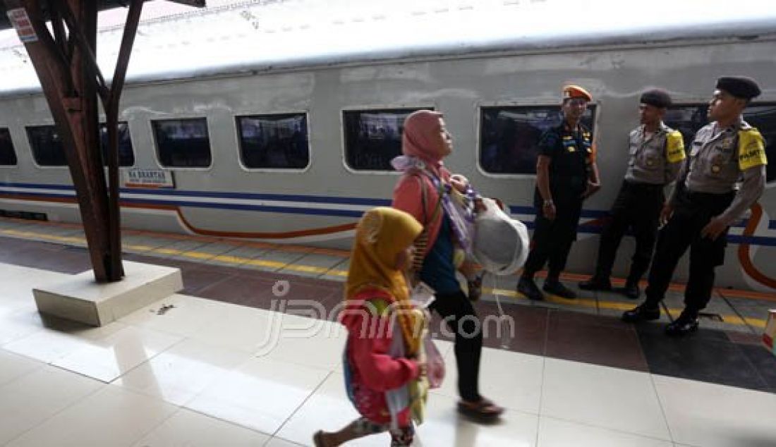 Petugas kepolisian berjaga di area peron Stasiun Pasar Senen, Jakarta, Rabu (29/6). Pengamanan dari aparat kepolisian ini bertujuan untuk memberikan keamanan dan kenyamanan bagi para pemudik pengguna jasa kereta api. Foto: Ismail/Indopos - JPNN.com