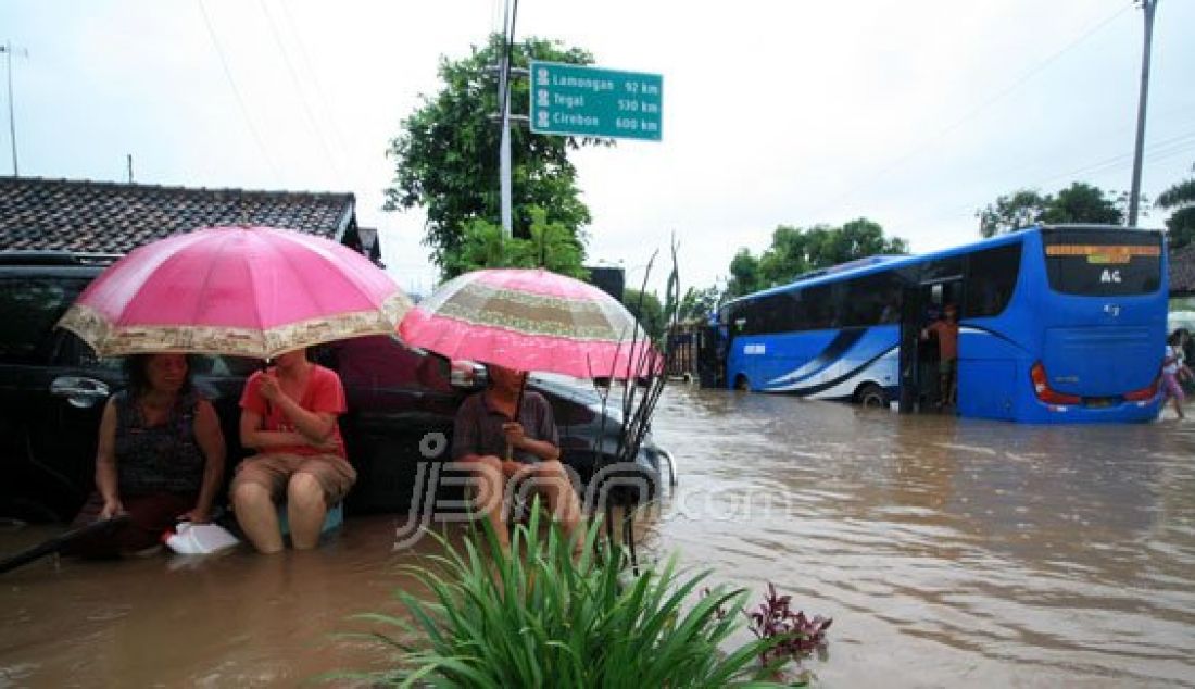 Warga terpaksa keluar rumah untuk mengamankan diri dari bahaya banjir. Tampak pula luapan air menggenangi mako Polsek Gadingrejo, Kota Pasuruan, Kamis (30/6). Foto: M Zubaidillah/Radar Bromo - JPNN.com