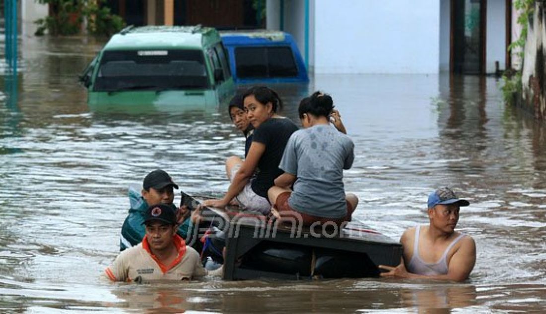 Tim BPBD Kabupaten Pasuruan sedang mengevakuasi warga Desa Tambakrejo, Kecamatan Kraton, Kabupaten Pasuruan, yang rumahnya terendam banjir, Kamis (30/6). Foto: M Zubaidillah/Radar Bromo - JPNN.com