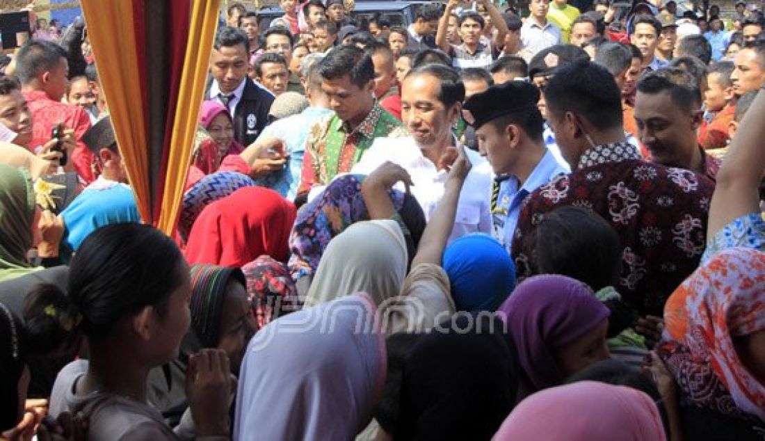 Presiden Joko Widodo menyalami warga saat mengantri untuk mendapatkan sembako di Kampung Kebanyakan, Kelurahan Sukawani, Kecamatan Serang, Kamis (30/6). Foto: Yan Cikal/Radar Banten - JPNN.com