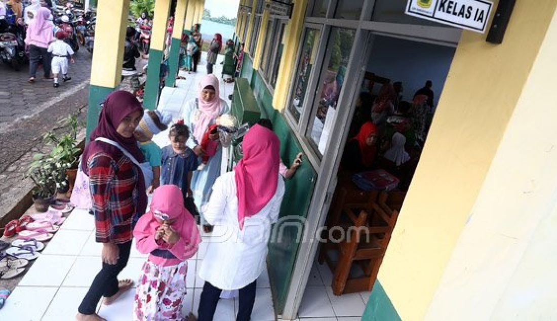 Orang tua siswa saat mengantarkan anaknya ke SDN Nanggerang 01, Tajurhalang, Kabupaten Bogor, Senin (18/7). Para orang tua sangat mendukung dengan intruksi Menteri Pendidikan dan Kebudayaan Anies Baswedan yang menghimbau agar orang tua mengantar anak di hari pertama sekolah dan bertemu dengan gurunya. Foto: Ricardo/JPNN.com - JPNN.com