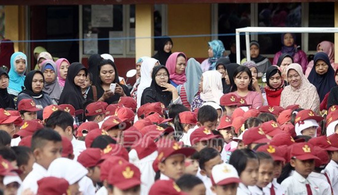 Orang tua siswa mengantarkan anaknya di SDN Nanggerang 02, Tajuhalang, Bogor, Senin (18/7). Para orang tua sangat mendukung intruksi Menteri Pendidikan dan Kebudayaan Anies Baswedan yang menghimbau agar orang tua mengantar anak di hari pertama sekolah dan bertemu dengan gurunya. Foto: Ricardo/JPNN.com - JPNN.com