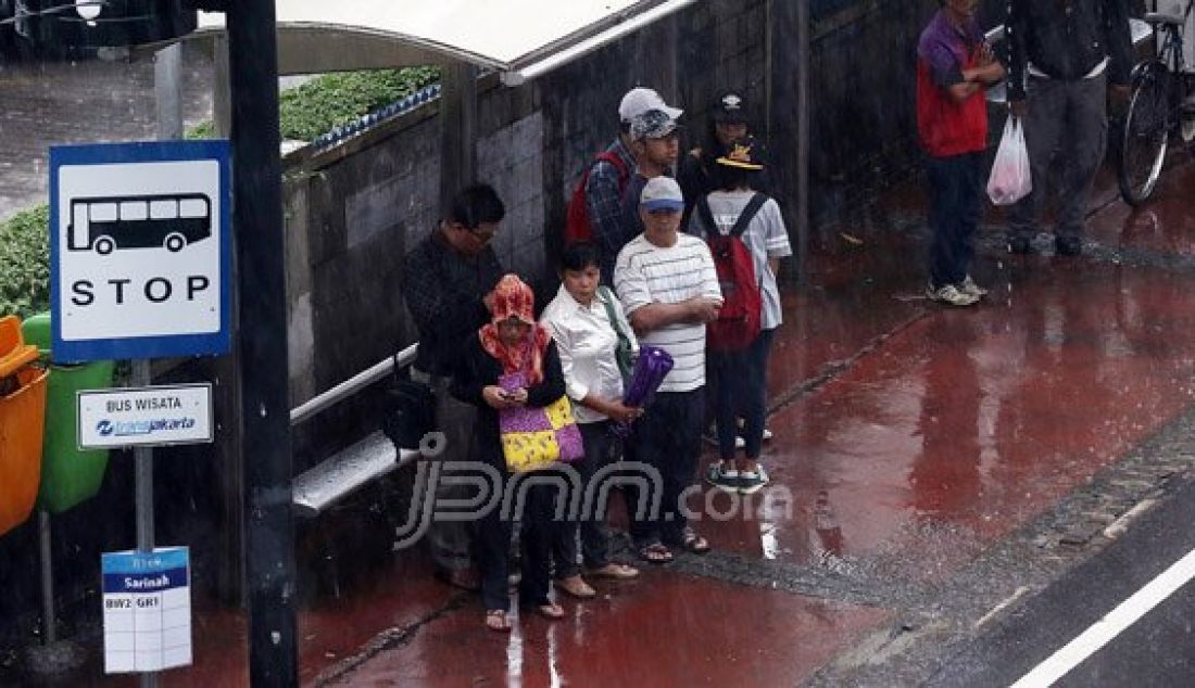 Sejumlah pejalan kaki menyebrangi Jl. MH Thamrin saat hujan deras mengguyur kawasan Sarinah Thamrin, Jakarta, Rabu (20/7). Menurut Sub-Bidang Informasi Meteorologi BMKG. musim kemarau tahun ini akan mundur dari siklus musim kemarau pada umumnya. Foto: Ricardo/JPNN.com - JPNN.com