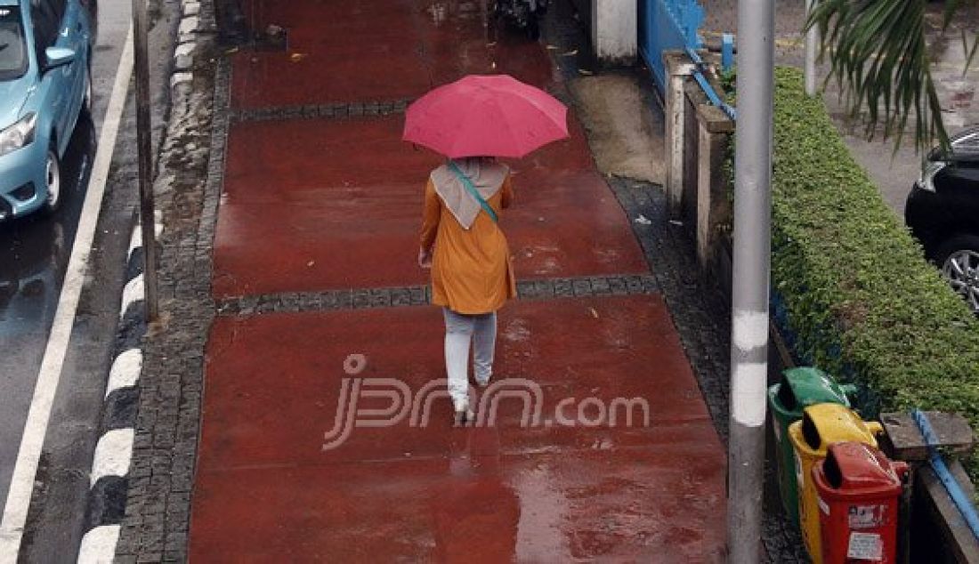 Sejumlah pejalan kaki menyebrangi Jl. MH Thamrin saat hujan deras mengguyur kawasan Sarinah Thamrin, Jakarta, Rabu (20/7). Menurut Sub-Bidang Informasi Meteorologi BMKG. musim kemarau tahun ini akan mundur dari siklus musim kemarau pada umumnya. Foto: Ricardo/JPNN.com - JPNN.com