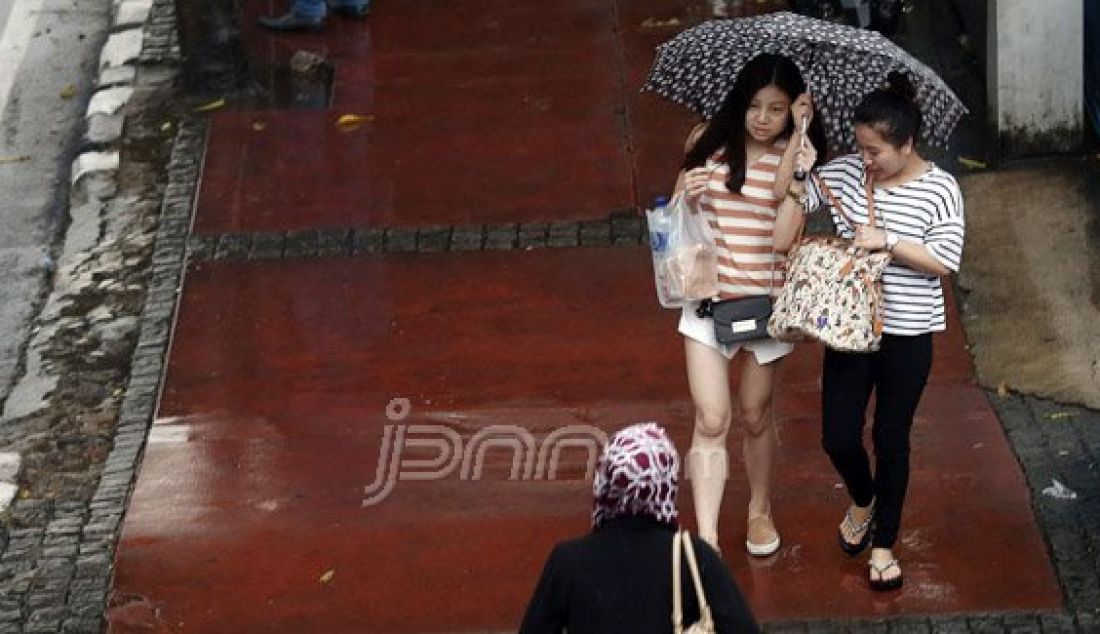 Sejumlah pejalan kaki menyebrangi Jl. MH Thamrin saat hujan deras mengguyur kawasan Sarinah Thamrin, Jakarta, Rabu (20/7). Menurut Sub-Bidang Informasi Meteorologi BMKG. musim kemarau tahun ini akan mundur dari siklus musim kemarau pada umumnya. Foto: Ricardo/JPNN.com - JPNN.com