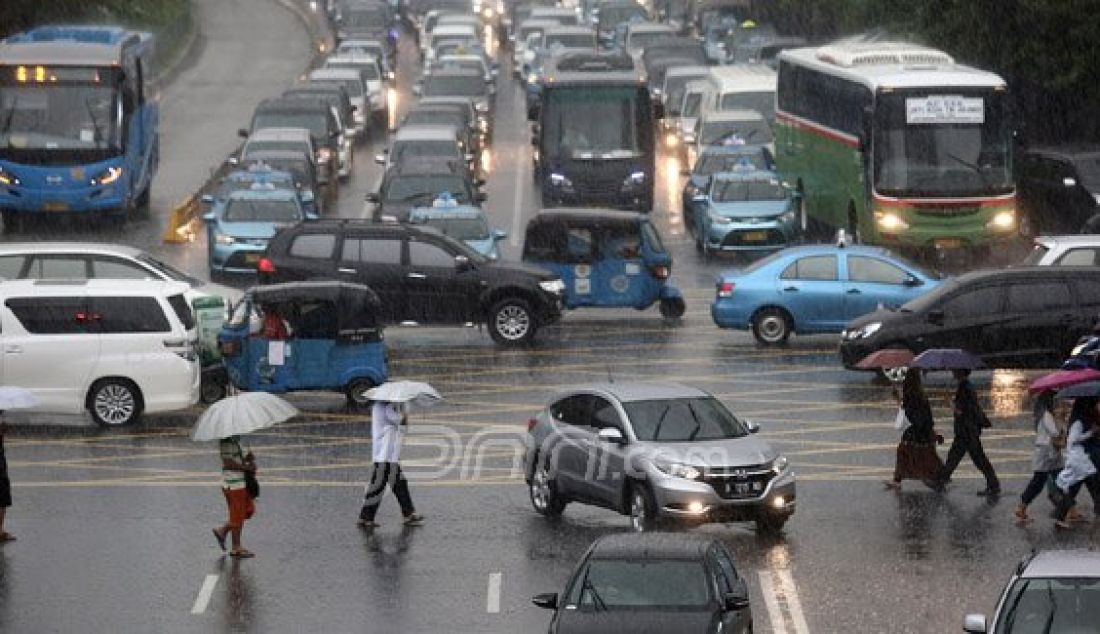 Sejumlah pejalan kaki menyebrangi Jl. MH Thamrin saat hujan deras mengguyur kawasan Sarinah Thamrin, Jakarta, Rabu (20/7). Menurut Sub-Bidang Informasi Meteorologi BMKG. musim kemarau tahun ini akan mundur dari siklus musim kemarau pada umumnya. Foto: Ricardo/JPNN.com - JPNN.com