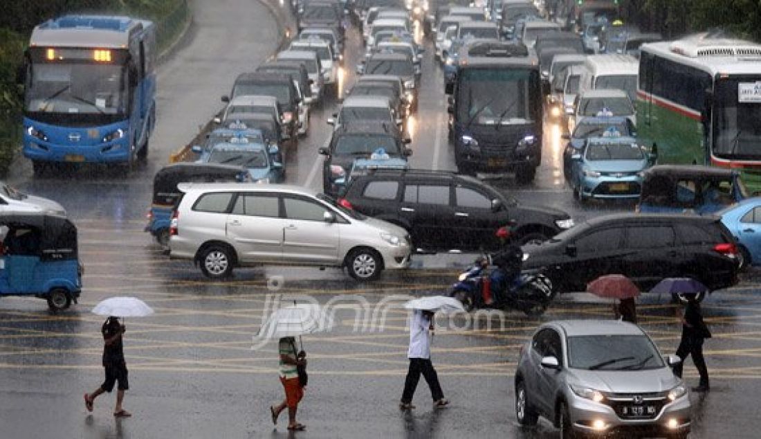 Sejumlah pejalan kaki menyebrangi Jl. MH Thamrin saat hujan deras mengguyur kawasan Sarinah Thamrin, Jakarta, Rabu (20/7). Menurut Sub-Bidang Informasi Meteorologi BMKG. musim kemarau tahun ini akan mundur dari siklus musim kemarau pada umumnya. Foto: Ricardo/JPNN.com - JPNN.com