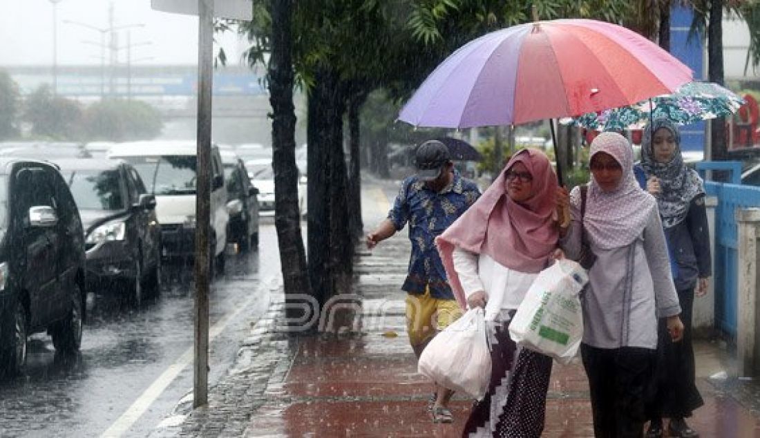 Sejumlah pejalan kaki menyebrangi Jl. MH Thamrin saat hujan deras mengguyur kawasan Sarinah Thamrin, Jakarta, Rabu (20/7). Menurut Sub-Bidang Informasi Meteorologi BMKG. musim kemarau tahun ini akan mundur dari siklus musim kemarau pada umumnya. Foto: Ricardo/JPNN.com - JPNN.com