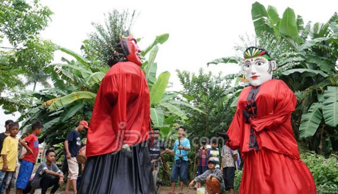 Pengamen ondel-ondel saat menghibur anak-anak di daerah Neglasari, Tangerang, Banten, Kamis (21/7). Sepinya order ondel-ondel untuk pesta pernikahan membuat mereka mengamen berkeliling kampung dengan pendapat yang cukup besar mencapai Rp 800.000/hari. Foto:Adrianto/Indopos - JPNN.com