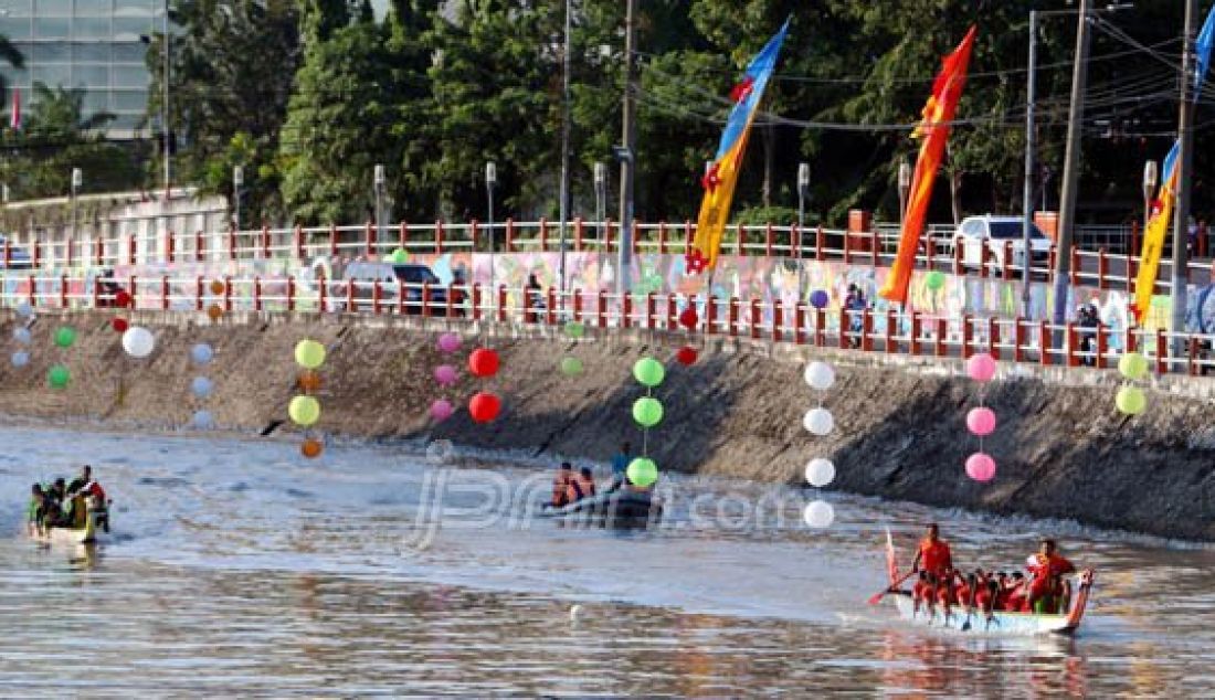 Dua tim perahu naga peserta lomba saat tampil memeriahkan penyelenggaraan Prepatory Committe 3 for UN Habitat di Surabaya, berlomba menuju garis finish di Kali Mas samping Monkasel, Senin (25/7). Foto: Satria/Radar Surabaya - JPNN.com