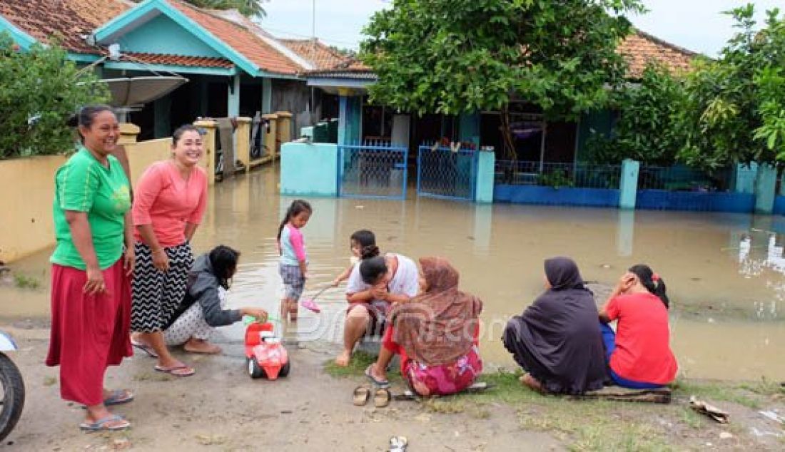 Warga menunggu didepan rumahnya karena kebanjiran di Lingkungan Cilodan, Kelurahan Gunung Sugih, Ciwandan, Cilegon, Senin (25/7). Banjir setinggi 1 M hingga 1,5 M ini akibat diguyur hujan hampir semalaman. Foto: Doni/Banten Raya - JPNN.com