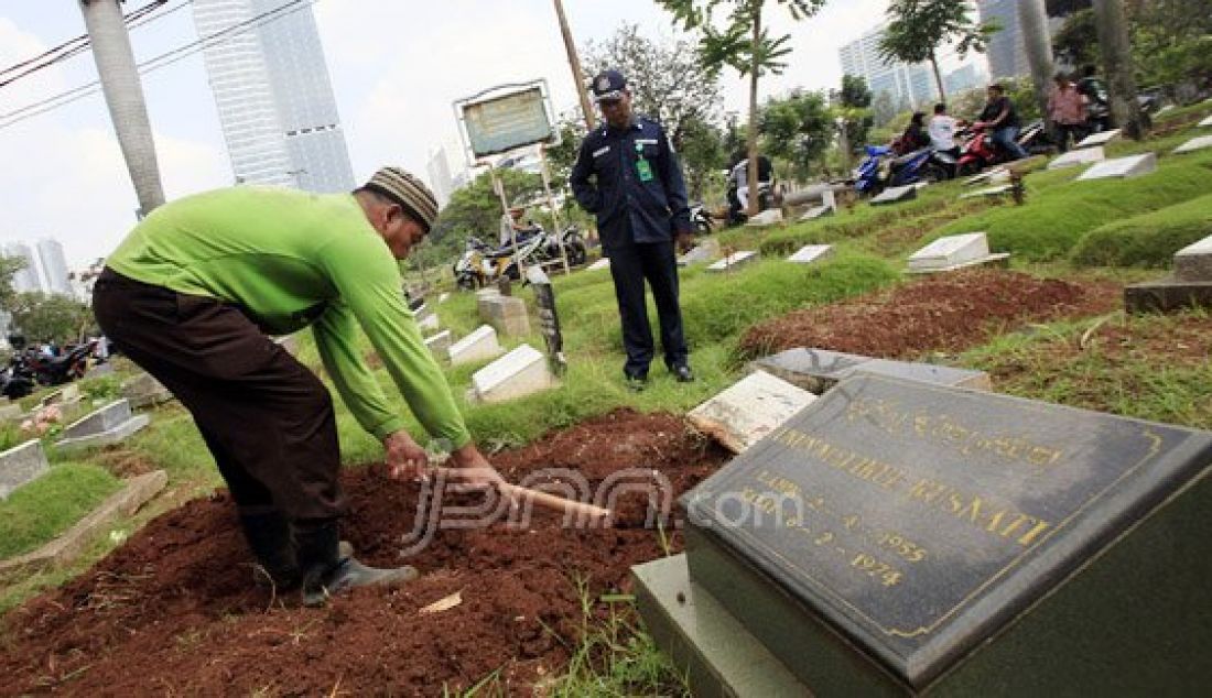 Petugas membongkar sebuah makam fiktif dengan batu nisan bertuliskan BAYI di Taman Pemakaman Umum (TPU) Menteng Pulo, Jakarta Selatan, Kamis (28/7). Sebanyak 11 makam fiktif berada di beberapa blok di Menteng Pulo. Foto: Ricardo/JPNN.com - JPNN.com