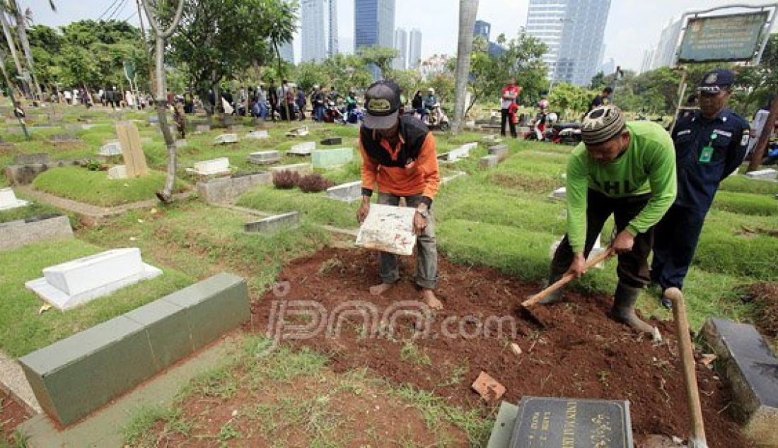 Petugas membongkar sebuah makam fiktif dengan batu nisan bertuliskan BAYI di Taman Pemakaman Umum (TPU) Menteng Pulo, Jakarta Selatan, Kamis (28/7). Sebanyak 11 makam fiktif berada di beberapa blok di Menteng Pulo. Foto: Ricardo/JPNN.com - JPNN.com