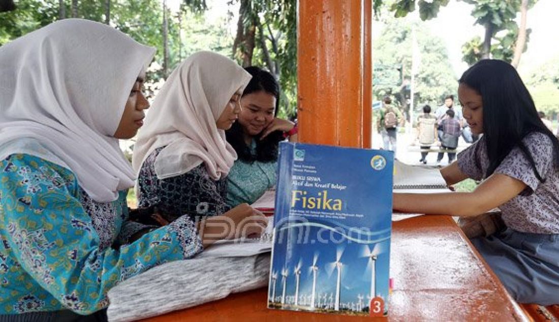 Sejumlah siswi SMA N 70 Jakarta belajar bersama usai pulang sekolah di Taman Sekolah SMA N 70 Jakarta, Jakarta, Kamis (4/8). Mereka memanfaatkan waktu kosong dengan mengulang pelajaran yang diberikan sekolah dari pada bermain Pokemon GO. Foto: Ricardo/JPNN.com - JPNN.com