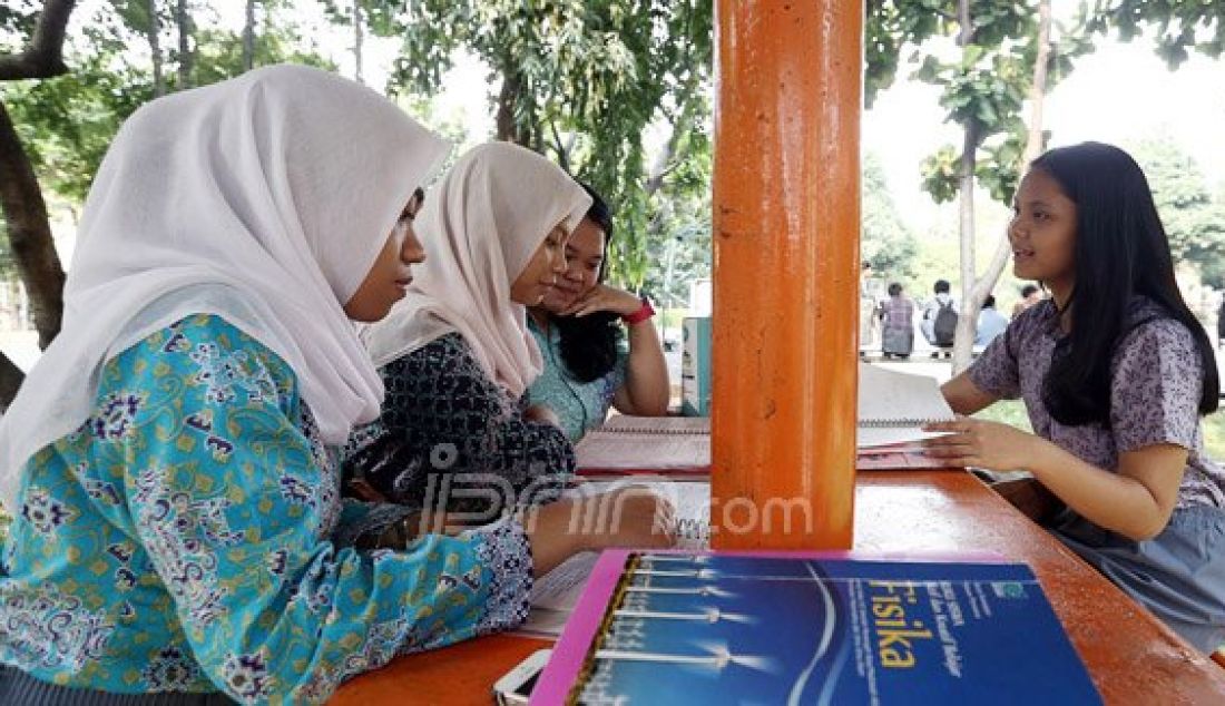 Sejumlah siswi SMA N 70 Jakarta belajar bersama usai pulang sekolah di Taman Sekolah SMA N 70 Jakarta, Jakarta, Kamis (4/8). Mereka memanfaatkan waktu kosong dengan mengulang pelajaran yang diberikan sekolah dari pada bermain Pokemon GO. Foto: Ricardo/JPNN.com - JPNN.com