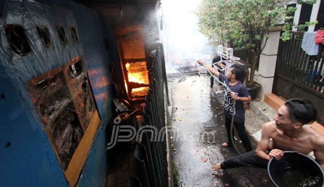 Petugas pemadam kebakaran bersama warga berusaha memadamkan api yang menghanguskan pemukiman penduduk di Jalan Gelora IX A, Palmerah, Jakarta, Kamis (4/8). Kebakaran yang menghanguskan delapan rumah tersebut diduga berasal karena korsleting listrik. Foto: Ricardo/JPNN.com - JPNN.com