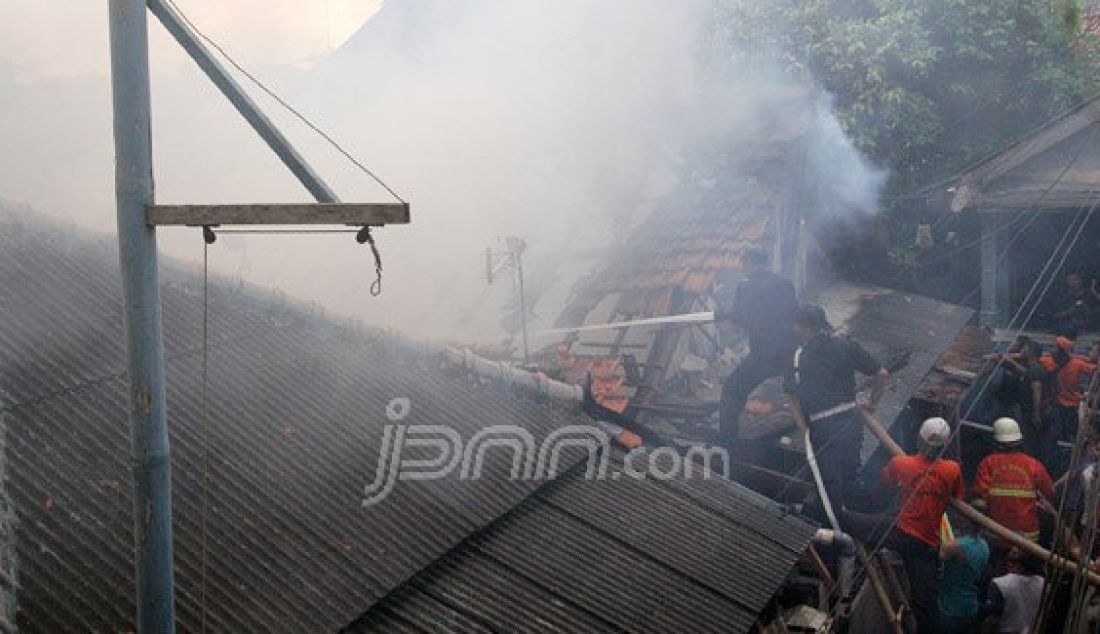 Petugas pemadam kebakaran bersama warga berusaha memadamkan api yang menghanguskan pemukiman penduduk di Jalan Gelora IX A, Palmerah, Jakarta, Kamis (4/8). Kebakaran yang menghanguskan delapan rumah tersebut diduga berasal karena korsleting listrik. Foto: Ricardo/JPNN.com - JPNN.com