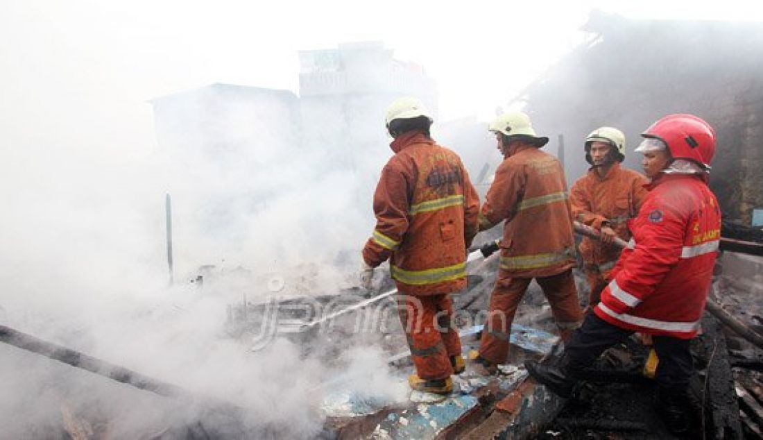 Petugas pemadam kebakaran bersama warga berusaha memadamkan api yang menghanguskan pemukiman penduduk di Jalan Gelora IX A, Palmerah, Jakarta, Kamis (4/8). Kebakaran yang menghanguskan delapan rumah tersebut diduga berasal karena korsleting listrik. Foto: Ricardo/JPNN.com - JPNN.com