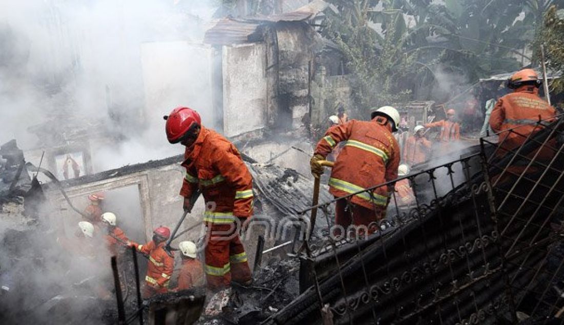 Petugas pemadam kebakaran bersama warga berusaha memadamkan api yang menghanguskan pemukiman penduduk di Jalan Kp Duku, Kebayoran Lama, Jakarta, Jumat (5/8). Empat unit mobil pemadam diterjunkan dalam kebakaran yang diduga akibat korsleting listrik. Foto: Ricardo/JPNN.com - JPNN.com