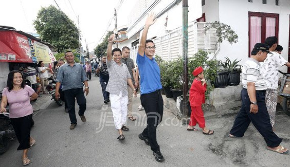 Bakal calon gubernur DKI Jakarta dari Partai Gerindra Sandiaga Uno mengunjungi warga Duri Kepa, Jakarta Barat, Minggu (7/8). Dia mengapresiasi kepada warga tersebut yang saling gotong royong dalam perbaikan jalan gang. Foto : Ricardo/JPNN.com - JPNN.com