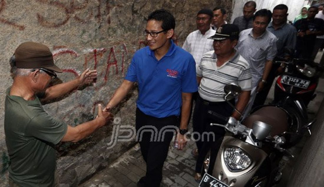 Bakal calon gubernur DKI Jakarta dari Partai Gerindra Sandiaga Uno mengunjungi warga Duri Kepa, Jakarta Barat, Minggu (7/8). Dia mengapresiasi kepada warga tersebut yang saling gotong royong dalam perbaikan jalan gang. Foto : Ricardo/JPNN.com - JPNN.com