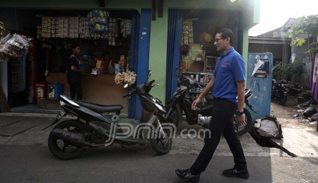 Bakal calon gubernur DKI Jakarta dari Partai Gerindra Sandiaga Uno mengunjungi warga Duri Kepa, Jakarta Barat, Minggu (7/8). Dia mengapresiasi kepada warga tersebut yang saling gotong royong dalam perbaikan jalan gang. Foto : Ricardo/JPNN.com - JPNN.com