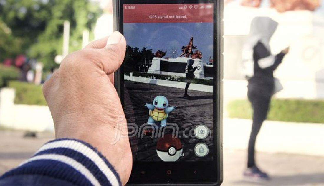 Bermain Pokemon Go di Kawasan Tugu Perjuangan di Jalan Diponegoro, Riau, Minggu (7/8). Kawasan Tugu Perjuangan dijadikan Pusat pertempuran para pemain Pokemon GO. Foto: Akhwan/Riau Pos - JPNN.com