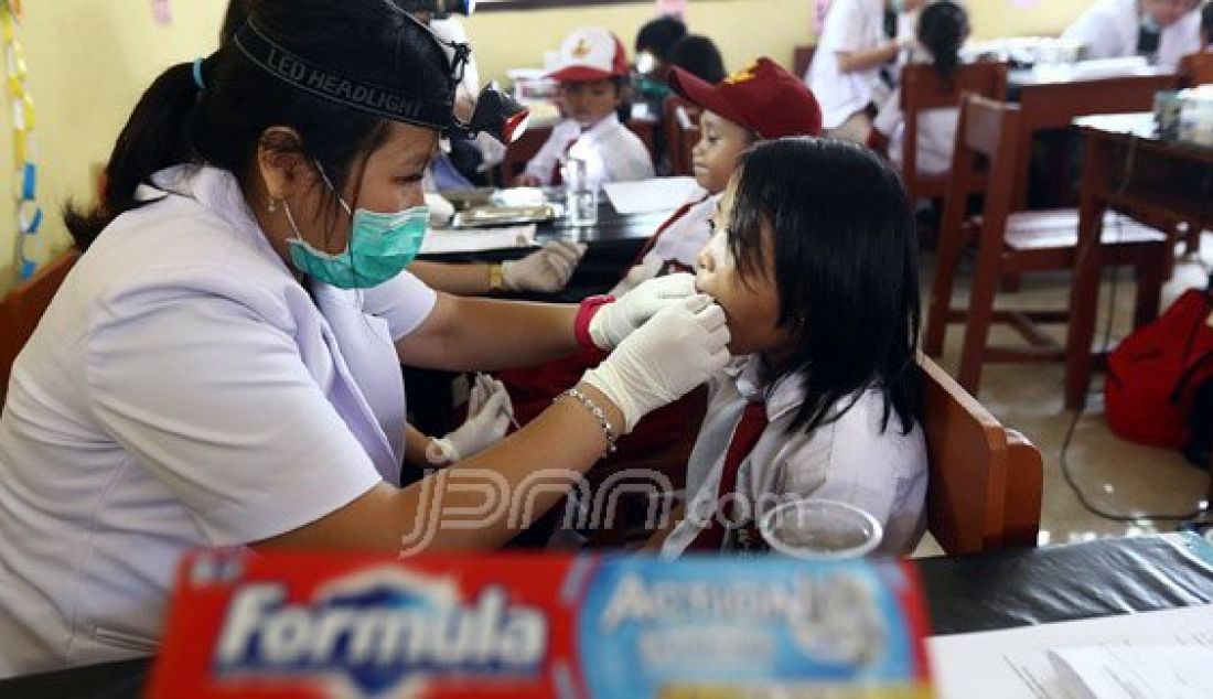 Seorang siswi sedang menjalankan perawatan gigi gratis yang diadakan oleh Formula dan FKG Trisakti, di SMPN 6 Pangkal Lalang Tanjung Pandan, Belitung (8/8). Acara ini merupakan bagian dari program sosial Formula untuk Indonesia yang bertujuan untuk menciptakan kesadaran masyarakat untuk merawat kesehatan gigi dan mulut. Foto : Ricardo/JPNN.com - JPNN.com