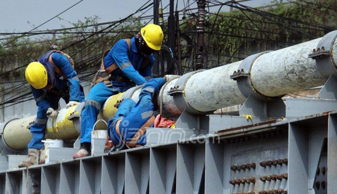 Petugas Perusahaan Gas Negara (PGN) melakukan perawatan rutin dan pengecatan terhadap pipa gas yang melintasi Kanal Banjir Barat (KBB) di wilayah Karet Bivak, Jakarta, Kamis (11/8). PGN menargetkan satu juta sambungan distribusi gas rumah tangga yang dimulai pada tahun ini. Foto: Ricardo/JPNN.com - JPNN.com