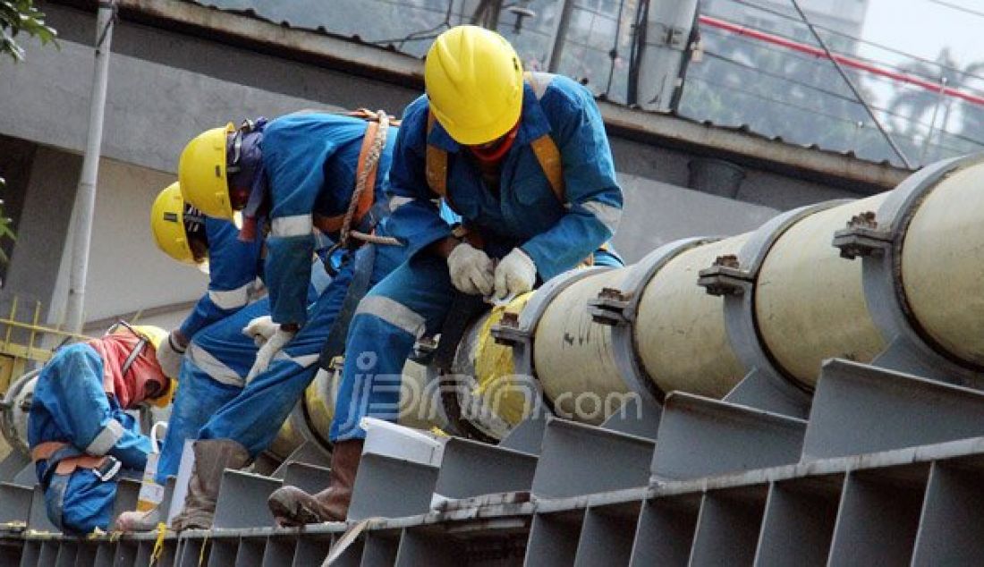 Petugas Perusahaan Gas Negara (PGN) melakukan perawatan rutin dan pengecatan terhadap pipa gas yang melintasi Kanal Banjir Barat (KBB) di wilayah Karet Bivak, Jakarta, Kamis (11/8). PGN menargetkan satu juta sambungan distribusi gas rumah tangga yang dimulai pada tahun ini. Foto: Ricardo/JPNN.com - JPNN.com