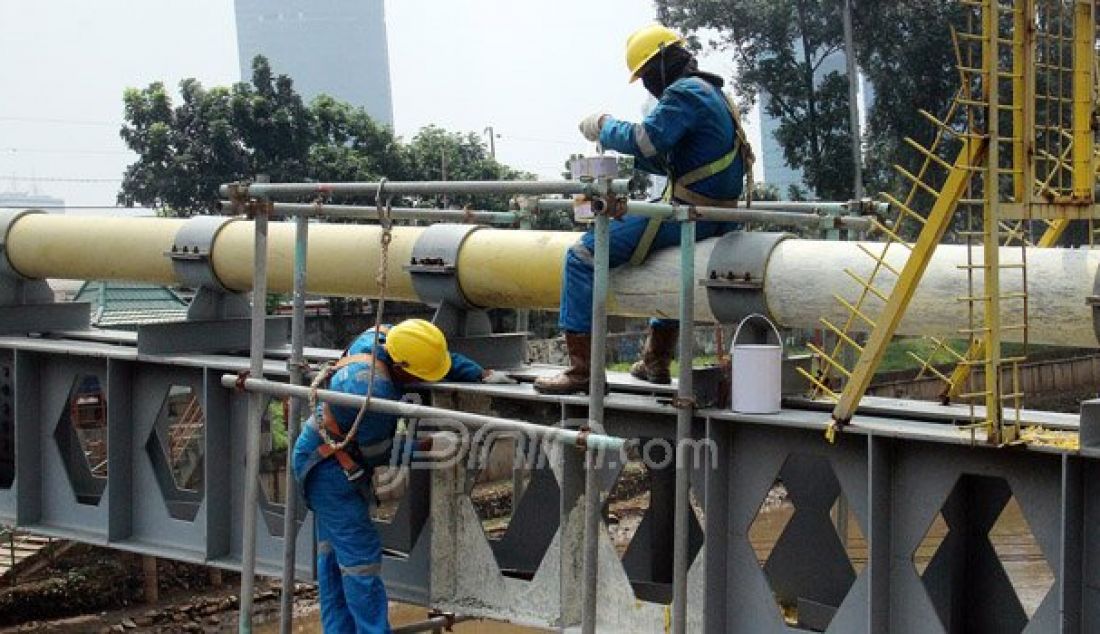 Petugas Perusahaan Gas Negara (PGN) melakukan perawatan rutin dan pengecatan terhadap pipa gas yang melintasi Kanal Banjir Barat (KBB) di wilayah Karet Bivak, Jakarta, Kamis (11/8). PGN menargetkan satu juta sambungan distribusi gas rumah tangga yang dimulai pada tahun ini. Foto: Ricardo/JPNN.com - JPNN.com