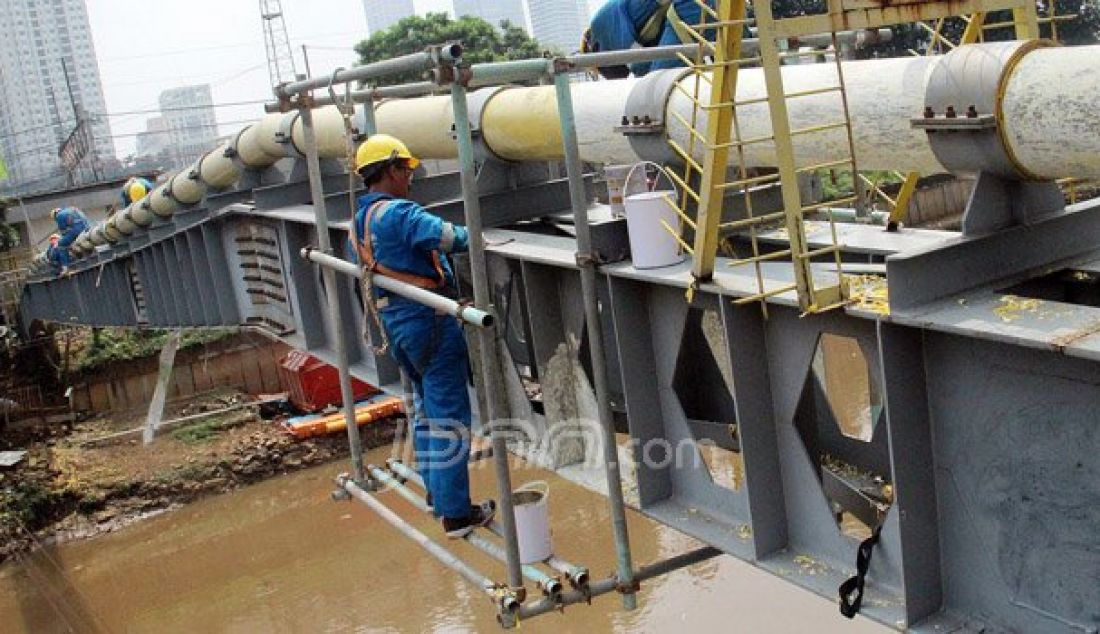 Petugas Perusahaan Gas Negara (PGN) melakukan perawatan rutin dan pengecatan terhadap pipa gas yang melintasi Kanal Banjir Barat (KBB) di wilayah Karet Bivak, Jakarta, Kamis (11/8). PGN menargetkan satu juta sambungan distribusi gas rumah tangga yang dimulai pada tahun ini. Foto: Ricardo/JPNN.com - JPNN.com