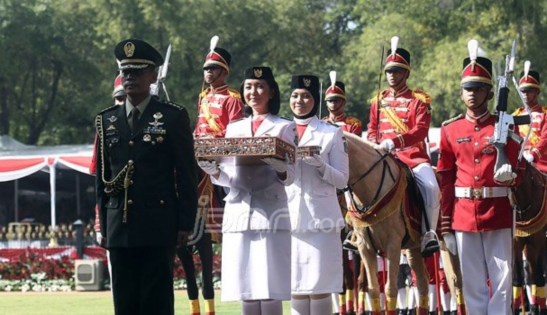 Pembawa Baki Bendera Pusaka Tahun Lalu, Maria Felicia Gunawan (depan) dan Pembawa Baki Bendera Pusaka Tahun Lalu Rani Oerinsan saat membawa arak-arakan Bendera Pusaka dari Monas tiba di halaman Istana Merdeka, Jakarta, Rabu (17/8). Foto: Ricardo/JPNN.com - JPNN.com