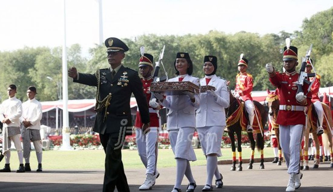 Pembawa Baki Bendera Pusaka Tahun Lalu, Maria Felicia Gunawan (depan) dan Pembawa Baki Bendera Pusaka Tahun Lalu Rani Oerinsan saat membawa arak-arakan Bendera Pusaka dari Monas tiba di halaman Istana Merdeka, Jakarta, Rabu (17/8). Foto: Ricardo/JPNN.com - JPNN.com