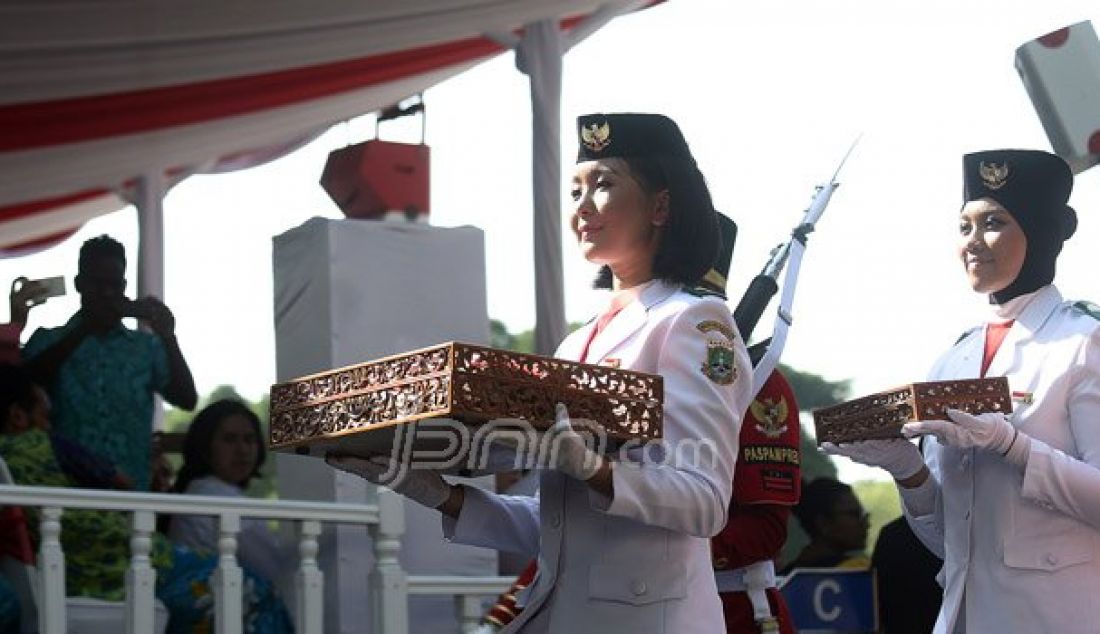 Pembawa Baki Bendera Pusaka Tahun Lalu, Maria Felicia Gunawan (depan) dan Pembawa Baki Bendera Pusaka Tahun Lalu Rani Oerinsan saat membawa arak-arakan Bendera Pusaka dari Monas tiba di halaman Istana Merdeka, Jakarta, Rabu (17/8). Foto: Ricardo/JPNN.com - JPNN.com