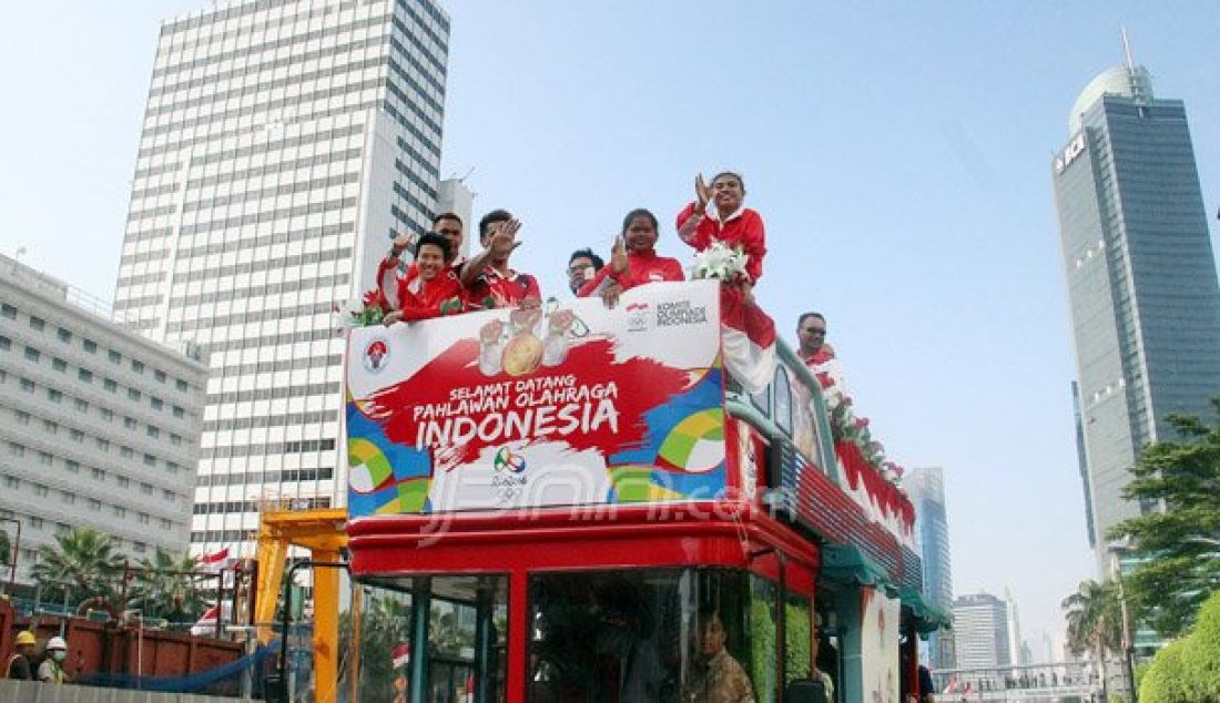 Sejumlah atlet yang mengikuti arak-arakan dengan menaiki bus Bandros menuju Istana Negara melintasi kawasan Jalan MH Thamrin, Jakarta, Rabu (24/8). Arak-arakan itu dilakukan guna menyambut para pahlawan olahraga. Foto: Ricardo/JPNN.com - JPNN.com