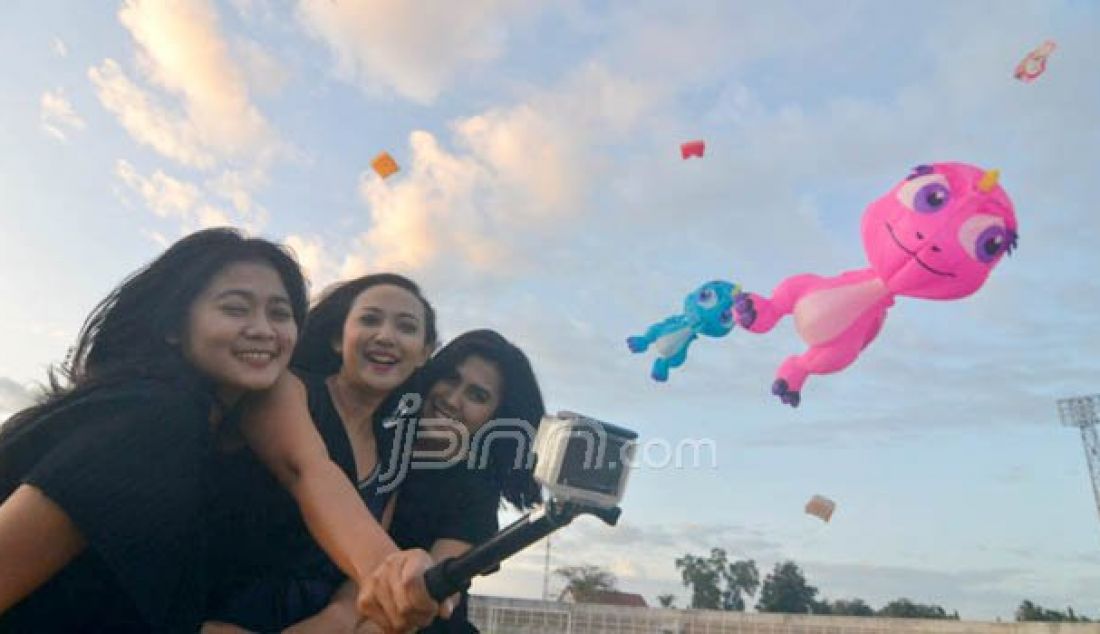Tiga wanita berselfie di antara layangan pada acara Jelajah layang-layang yang digelar di Stadion PKOR Wayhalim, Bandarlampung, Kamis (25/8). Jelajah Layang layang merupakan rangkaian dari Festival Krakatau 2016. Foto: Tegar/Radar Lampung - JPNN.com