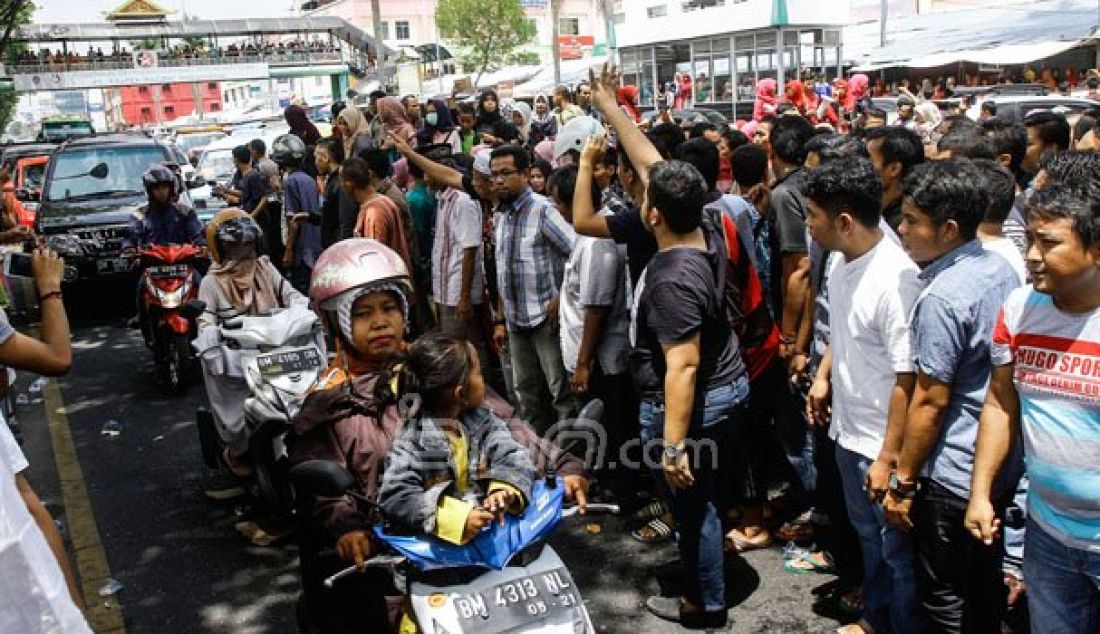 DEMO: Massa yang merupakan Pedagang Plaza Sukaramai memblokade badan jalan Jendral Sudirman, Pekanbaru, Riau, Jumat (26/8). Aksi blokade para pedagang ini membuat kemacetan panjang pun terjadi. Foto: M Akhwan/Riau Pos - JPNN.com