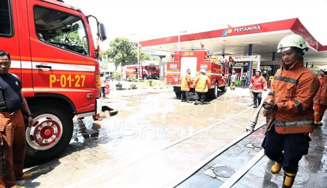 Petugas pemadam kebakaran melakukan pendinginan pada gudang pom bensin yang terbakar di Jalan Abdul Muis, Jakarta, Senin (12/9). Beruntung, petugas dapat menjinakkan api sehingga tidak merembet ke pom bensin yang tepat berada disampingnya. Foto: Ricardo/JPNN.com - JPNN.com