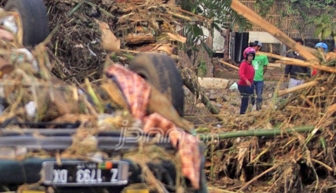 Warga mencari barang yang masih bisa terpakai usai terjadinya banjir bandang di kawasan Kabupaten Garut, Rabu (21/9). Tercatat, puluhan rumah sepanjang aliran sungai roboh diterjang banjir bandang. Foto: Khairizal/Radar Bandung - JPNN.com