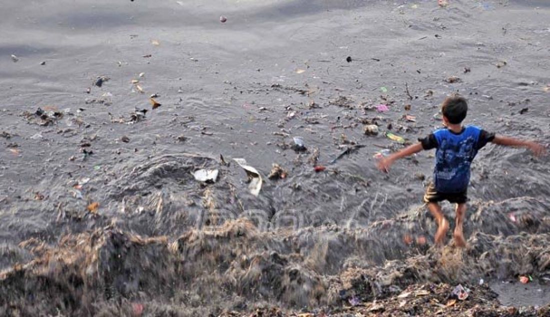 MASALAH KLASIK: Pantai dan laut bukan tempat sampah, namun masyarakat belum sadar untuk tidak membuang sampah sembarangan. Seorang anak bermain di pinggiran pantai Sindulang, Boulevard II, Kota Manado yang dipenuhi tumpukan sampah. Foto: Reza/Manado Post - JPNN.com