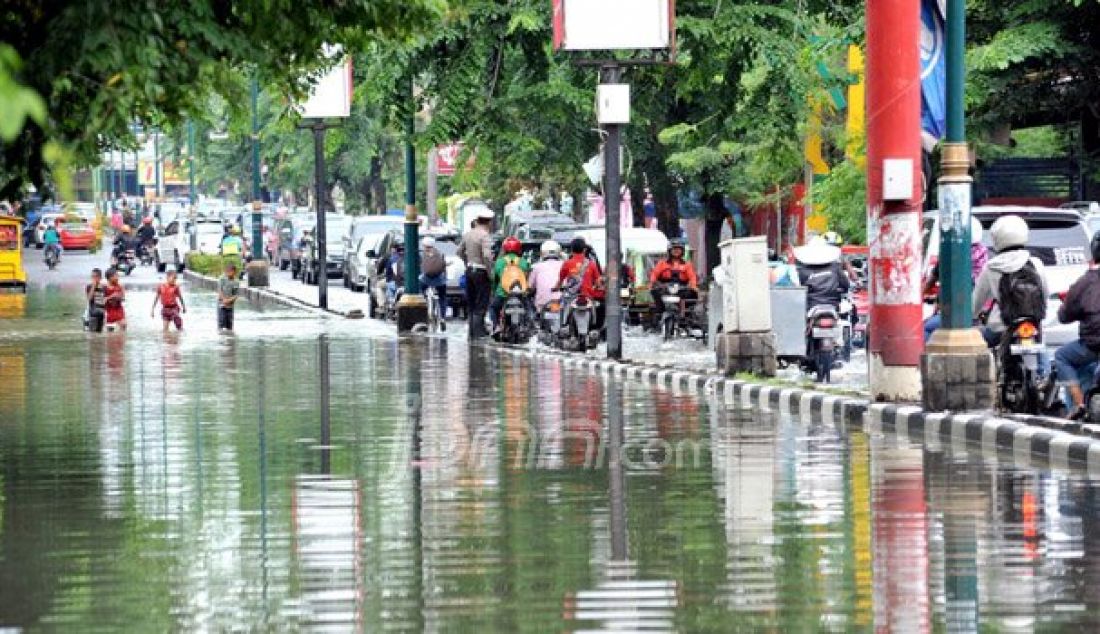 BANJIR: Kendaraan bermotor melintas genangan air yang membanjiri jalan Dr Mansur Medan, Kamis (30/9). Banjir tersebut disebabkan hujan deras pada hari sebelumnya dan buruknya saluran drainase. Foto: Sutan/Sumut Pos - JPNN.com