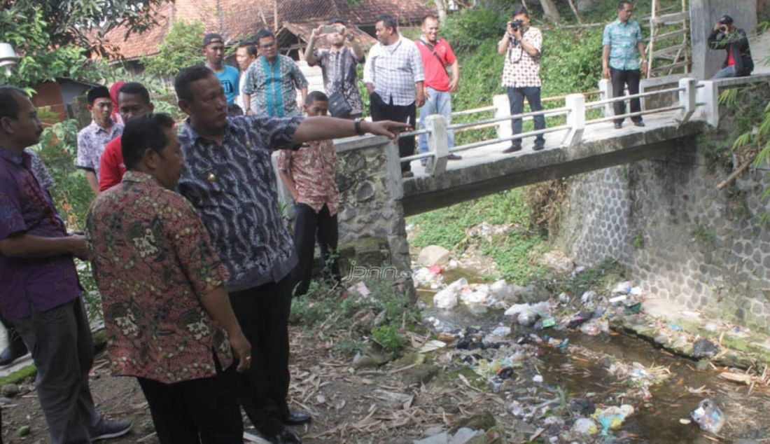 Minta Dibersihkan : Bupati Kuningan H Acep Purnama (menunjuk) marah dengan ulah warganya yang suka membuang sampah ke sungai, kemarin. Bupati meminta Kades Cikahuripan, Kabupaten Kuningan untuk membersihkan sungai yang dipenuhi sampah tersebut. Foto : Agus Panther/Radar Kuningan/JPNN.com - JPNN.com