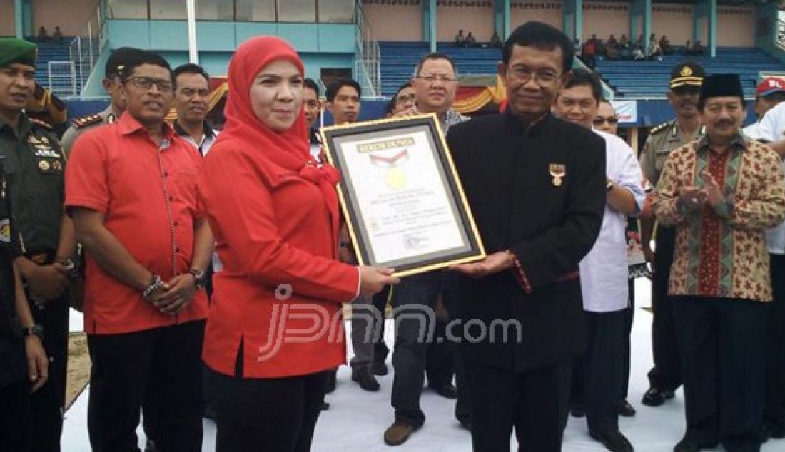 Penyerahan penghargaan Rekor Muri kategori papan catur terbesar dengan pionir manusia. Penghargaan diberikan oleh Senior Manager Museum Rekor Indonesia Jusuf Ngadri kepada Ketua KONI Lampung, Eva Dwiana di Stadion Pahoman, kemarin, (8/10). Foto : Tegar Mujahid/Radar lampung/JPNN.com - JPNN.com