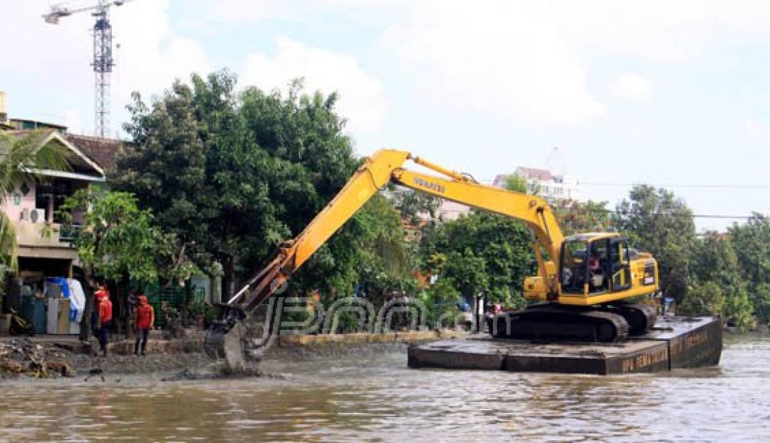 SAMBUT HUJAN: Pemkot Surabaya mengerahkan backhoe untuk mengeruk Sungai Kalimas. Pengerukan ini bagian dari antisipasi banjir yang disebabkan ketinggian sungai mencapai 130cm. Foto: Satria/Radar Surabaya - JPNN.com
