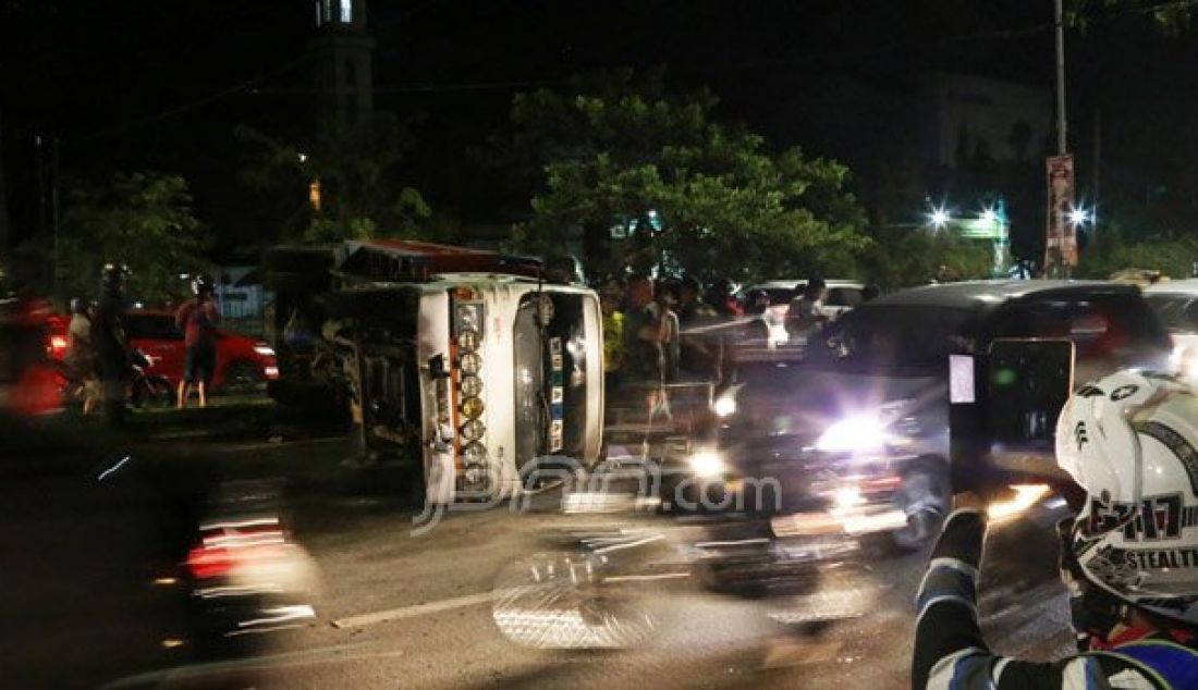 Truk nopol DD 8196 LA terguling di Jalan Urip Sumoharjo, Makassar, Jumat (21/10). Beruntung tak ada korban jiwa dalam peristiwa yang diduga akibat kelebihan muatan tersebut. Foto: M Idham/FAJAR - JPNN.com